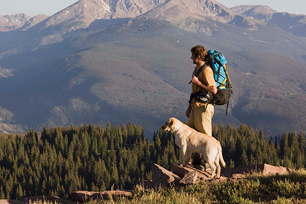 Man standing with his dog on mountainside